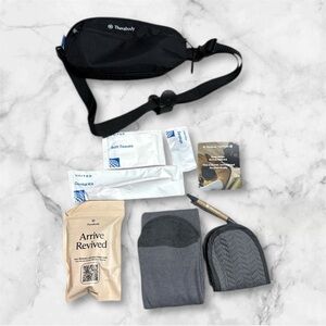 Therabody Black Waist Bag with travel essentials inside
